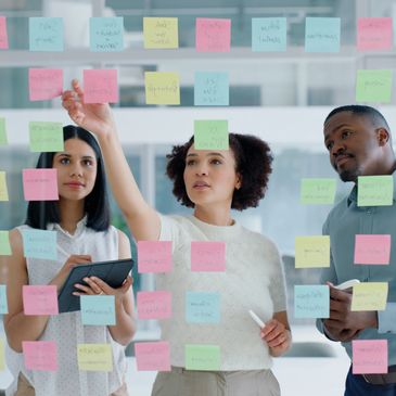 Diverse team collaborating on workplace strategy using sticky notes.