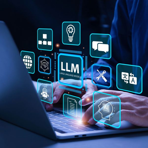 Hands typing on a laptop with floating icons representing large language models and AI technology.