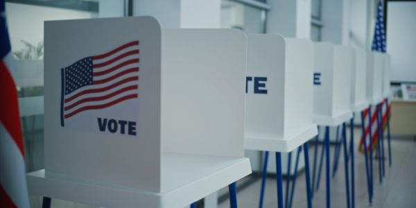 Row of voting booths with American flags.
