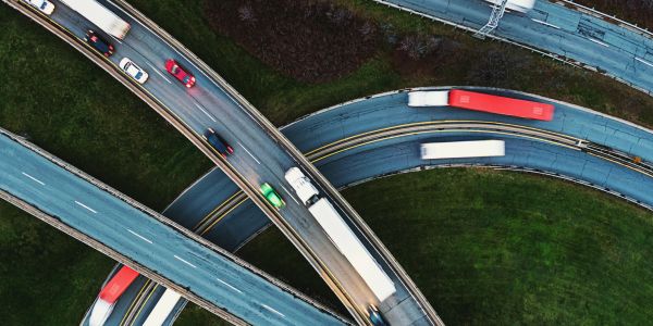 Aerial view of a highway interchange with vehicles moving on curved ramps.