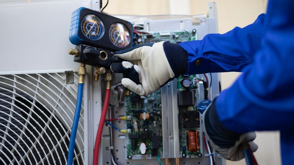 Bryant HVAC technician repairing an air conditioner in Oakland County, Michigan