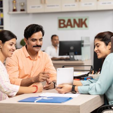 Couple consulting a bank employee with a tablet.