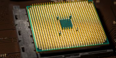 Close-up of a CPU with gold pins on a motherboard.