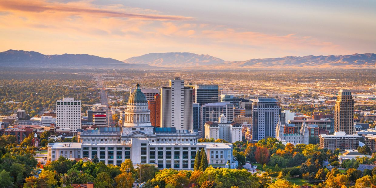 City skyline with mountains in the background at sunset.