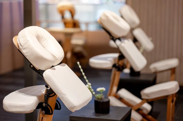 Massage chairs with white cushions in a spa setting.