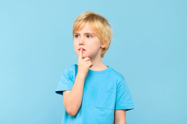 Thoughtful young boy in blue shirt.