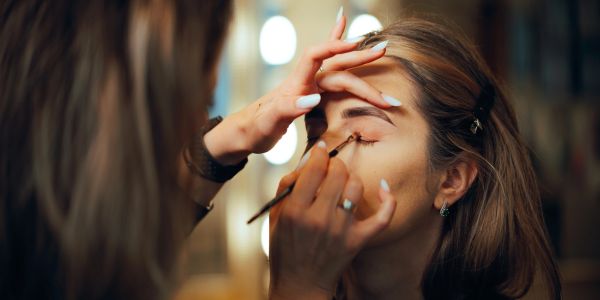 Une femme applique du maquillage sur les yeux d'une autre.