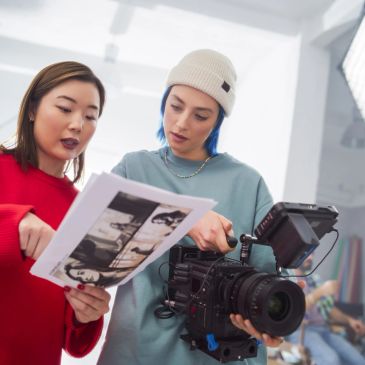 Deux femmes regardant un script près d'une caméra.