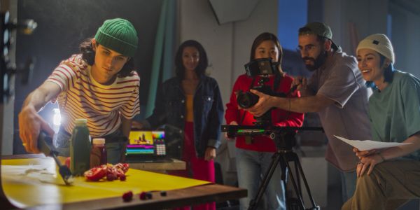 Group filming a food preparation scene.