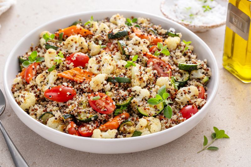 Quinoa salad with roasted vegetables, cauliflower and zucchini, and fresh herbs and tomatoes