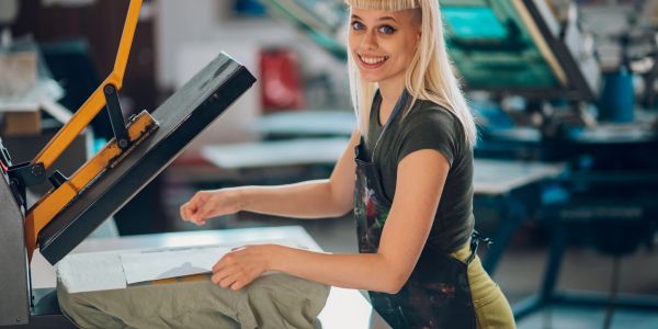 Jeune femme souriante utilisant une machine à imprimer.
