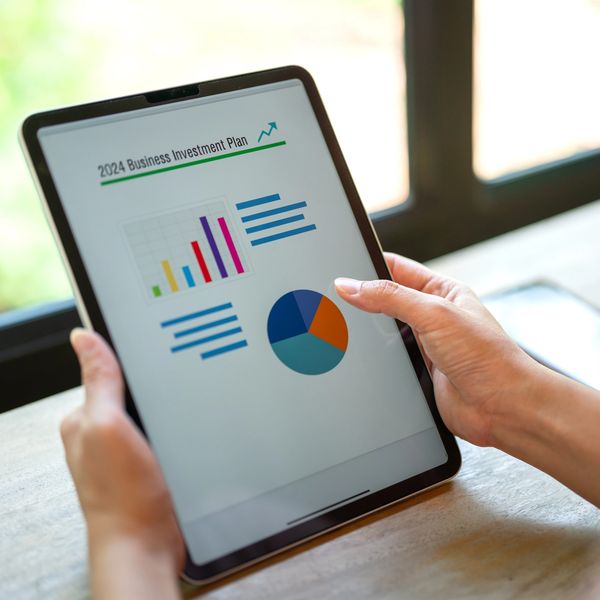 Persona observando las graficas en el plan de inversión de negocios 2024, desde una tableta