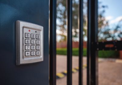 Close-up of a security keypad on a gate.