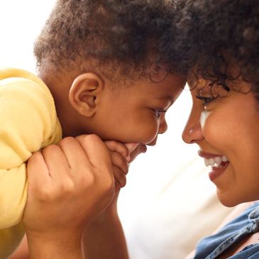 Mother and baby sharing a loving forehead touch moment.