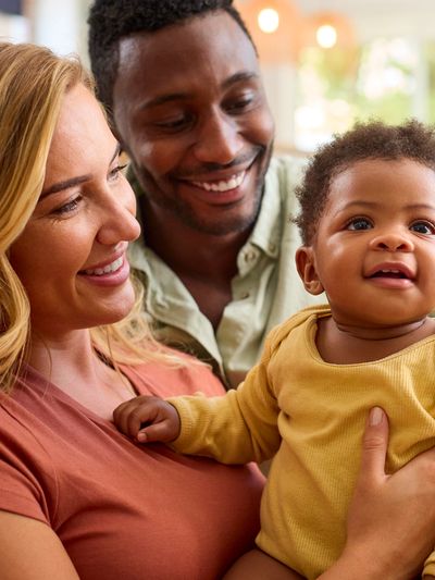 Happy family with smiling parents and baby.