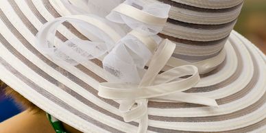 Elegant white and beige striped hat with a decorative bow.