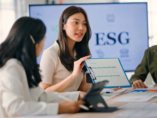Woman presenting at a business meeting with ESG focus.