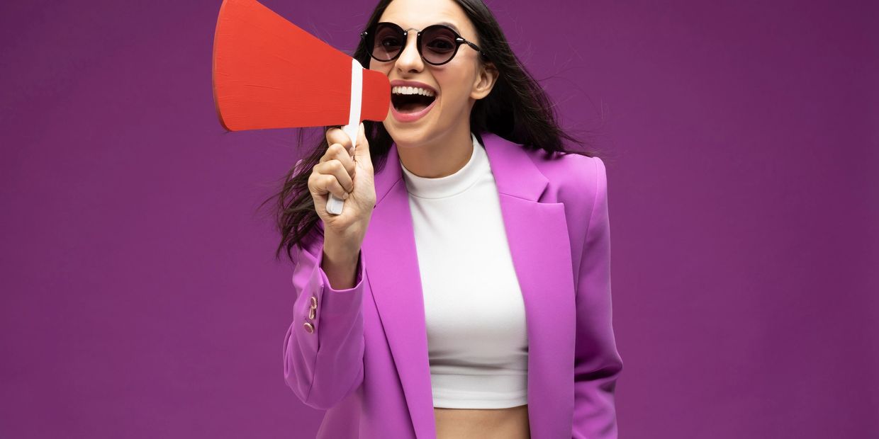Woman in purple suit with megaphone. 