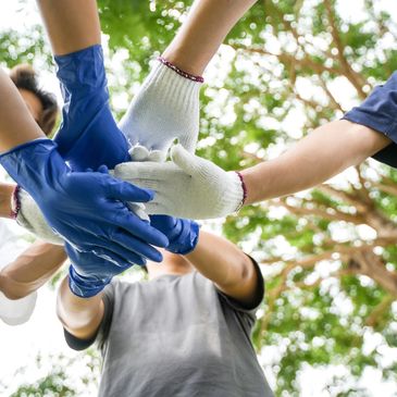 Group of people wearing gloves stacking hands in teamwork.