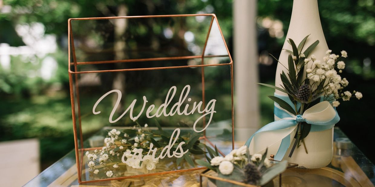 Elegant wedding card box with floral decorations and a bottle adorned with ribbons.