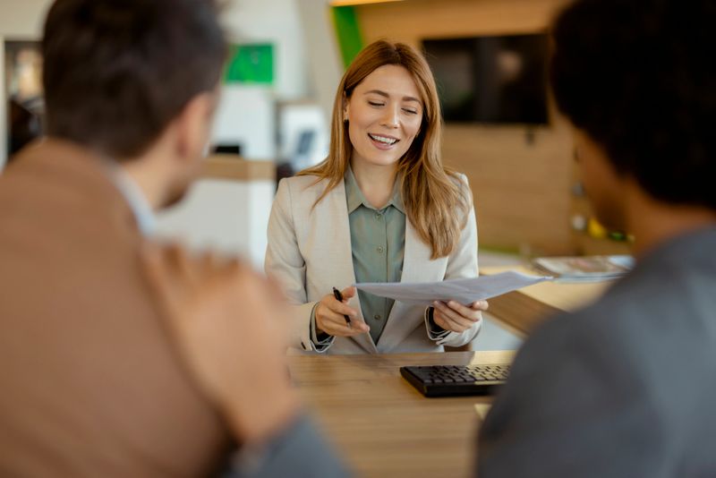 Happy Financial Advisor Talking to Mixed Race Couple During the Meeting