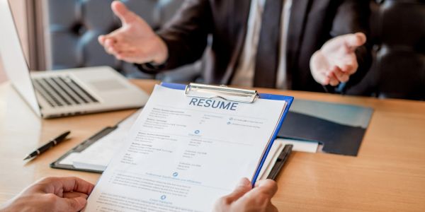 Resume being reviewed in a job interview setting.