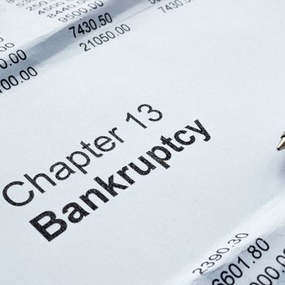 Close-up of a document titled 'Chapter 13 Bankruptcy' with financial figures and a pen.