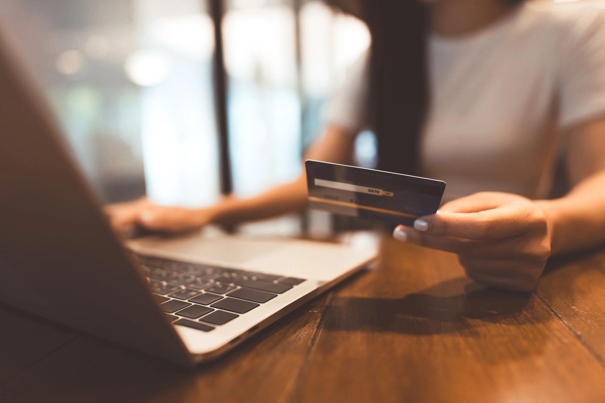 Woman paying a bill with a credit card from a laptop computer. 