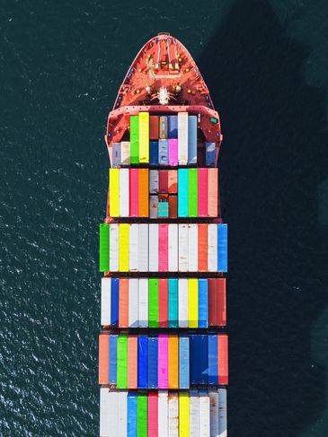 SHIP CARRYING CARGO IN CONTAINER SAILING SEAS AND OCEANS