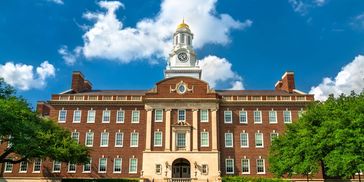 Historic brick building under a bright blue sky with white clouds.