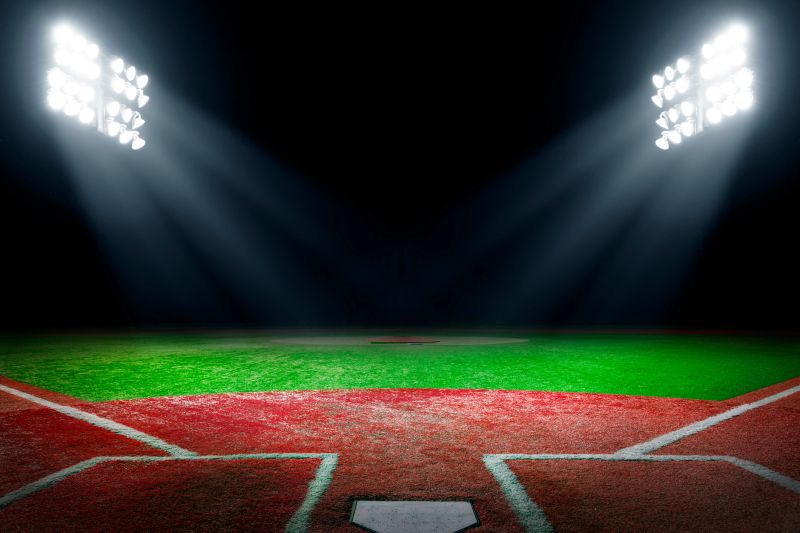 Baseball field at night with bright floodlights and copy space.