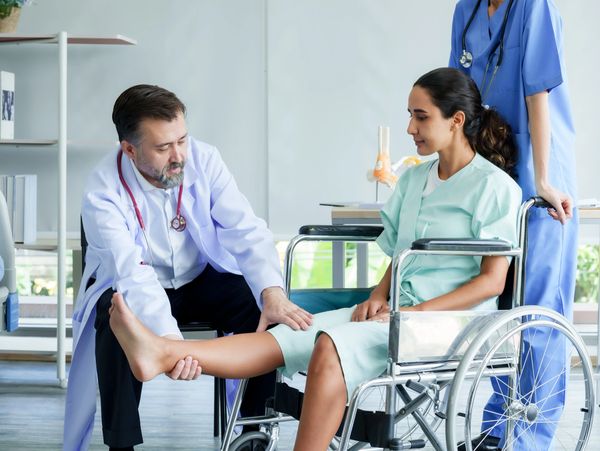 A doctor examining an Orthopaedic Patient's Knee for referred pain from the Hip into the Knee. 