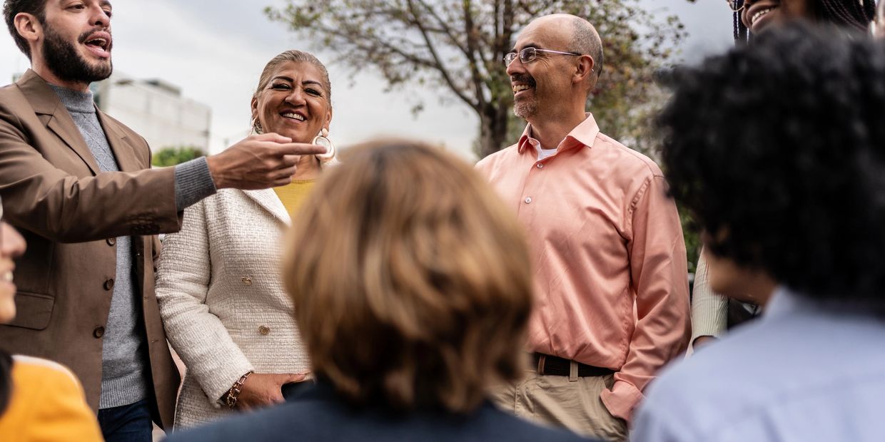 A group of diverse people enjoying a conversation outdoors.