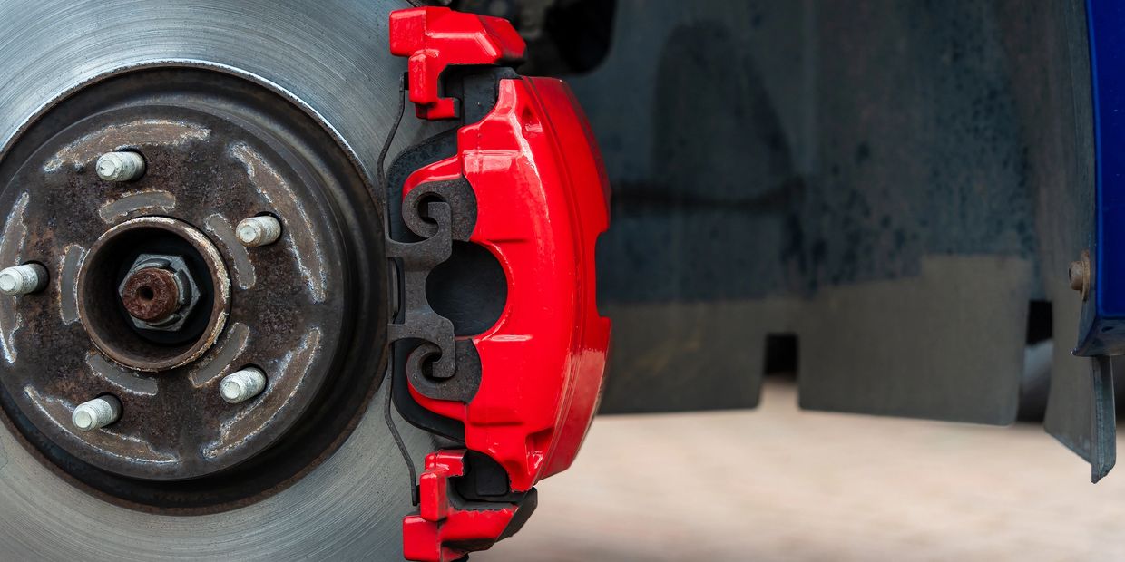 Close-up of a new car brake rotor and caliper during professional brake service in St. George, Utah