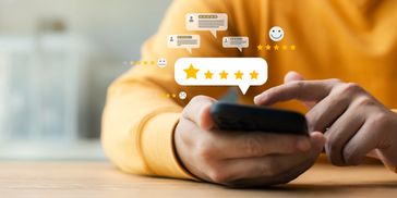 Person giving a five-star rating on a smartphone.