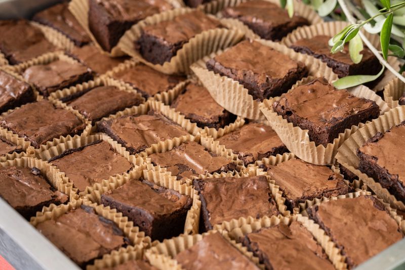 Large selection of delicious brownies cut in perfect squares to eat by hand.