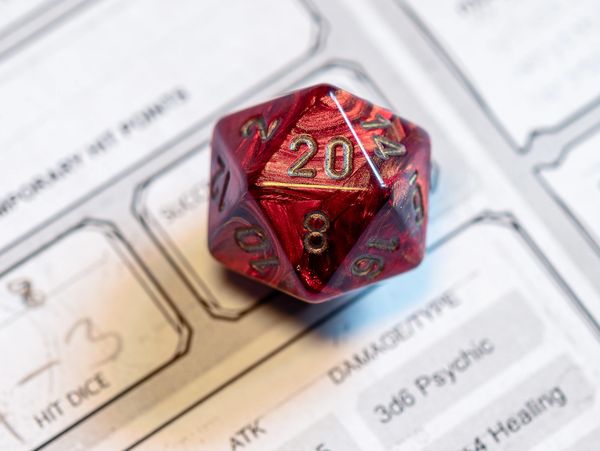 A 20-side die on a paper Dungeons and Dragons character sheet.