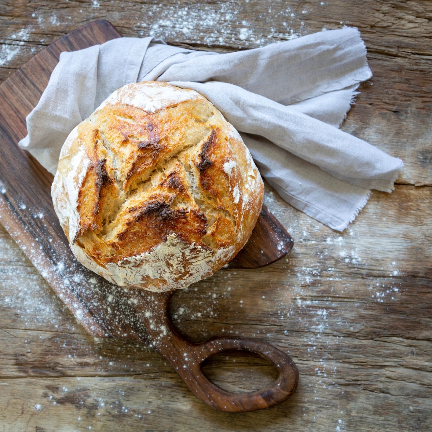 freshly baked small batch sourdough loaf on wooden board
