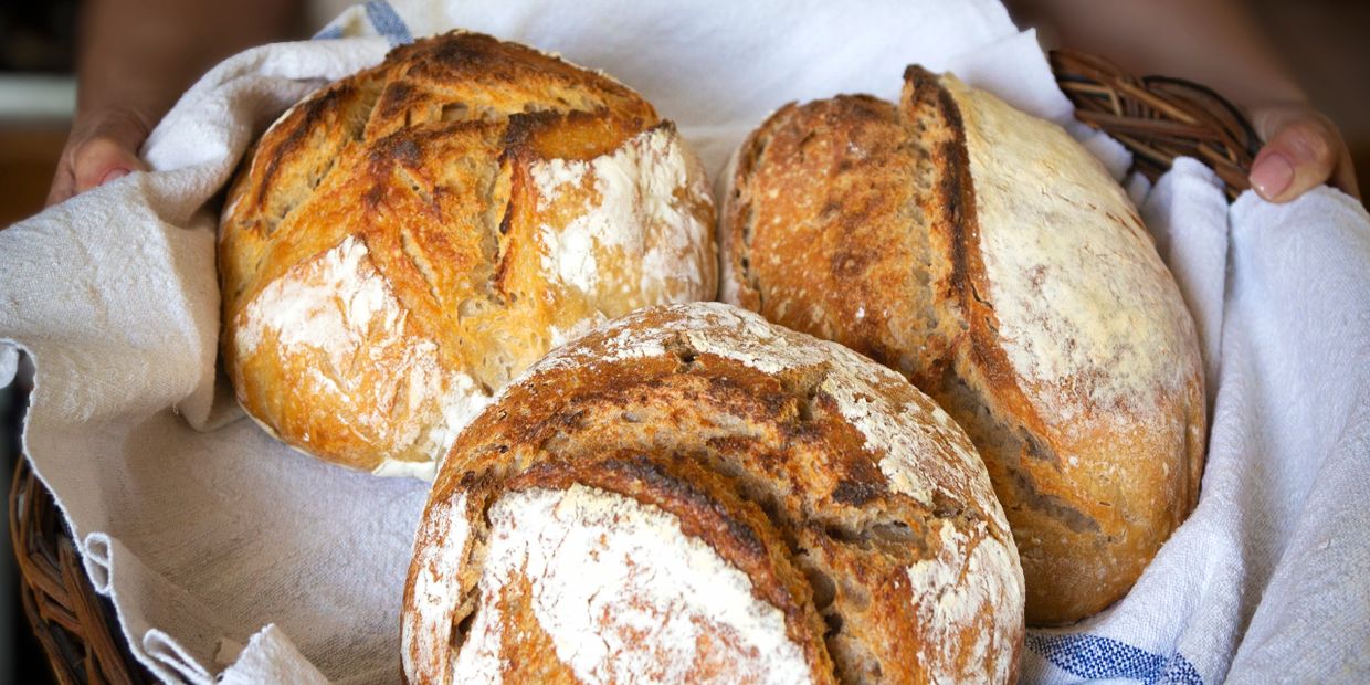 A basket of freshly baked artisanal bread loaves.