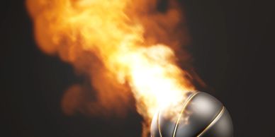 A basketball engulfed in flames flying through the air.