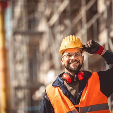 Construction worker smiling with safety gear.