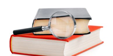 picture of a stack off books and a magnifying glass