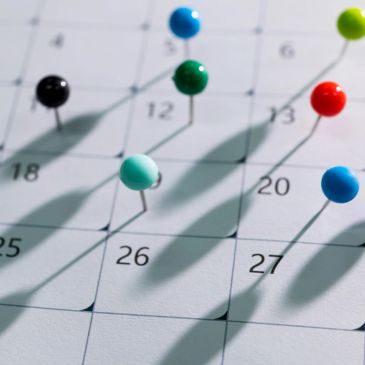 Colored push pins on calendar dates.