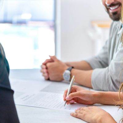 Person signing a document during a meeting.