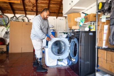 KERN COUNTY JUNK REMOVAL EMPLOYEE TAKING AN OLD WASHER FROM A KERN COUNTY RESIDENT'S HOME. 