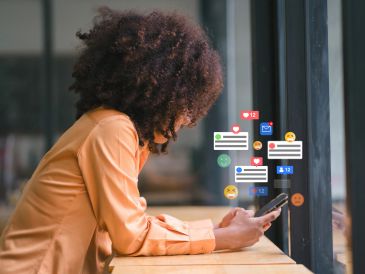Mujer usando su teléfono con notificaciones de redes sociales.