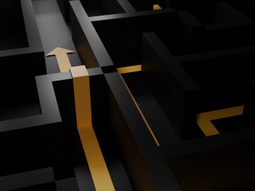 Illuminated path in a dark maze with an arrow.