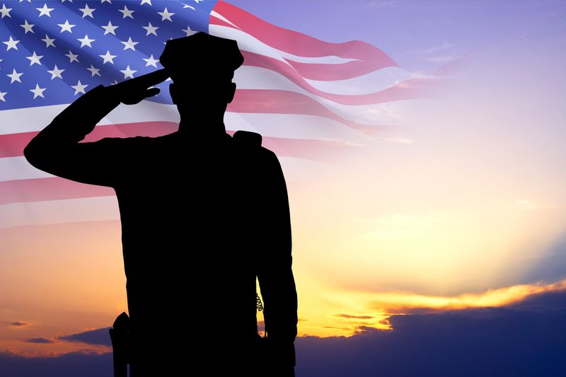 Silhouette of police man with USA flag against the sunset. National Police Week concept