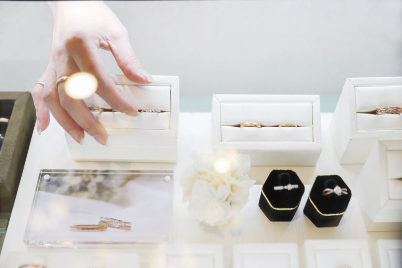 The female clerk in the jewelry store took out the jewelry on the counter and prepared to introduce it to the customers. There were diamond rings, pearl bracelets, jade pendants, etc., all kinds of high-end accessories on the counter.