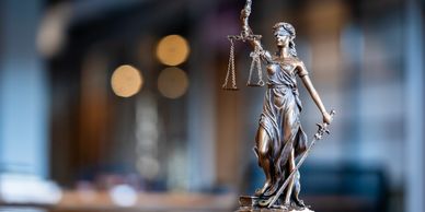 Statue of Lady Justice holding scales and a sword, symbolizing fairness and law.